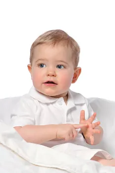 Un bébé fait un signe avec ses mains.